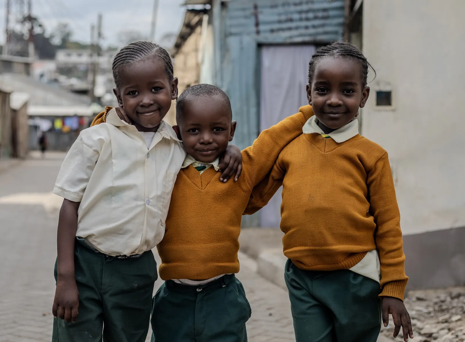 Three friends in CHIWO uniforms standing arm in arm