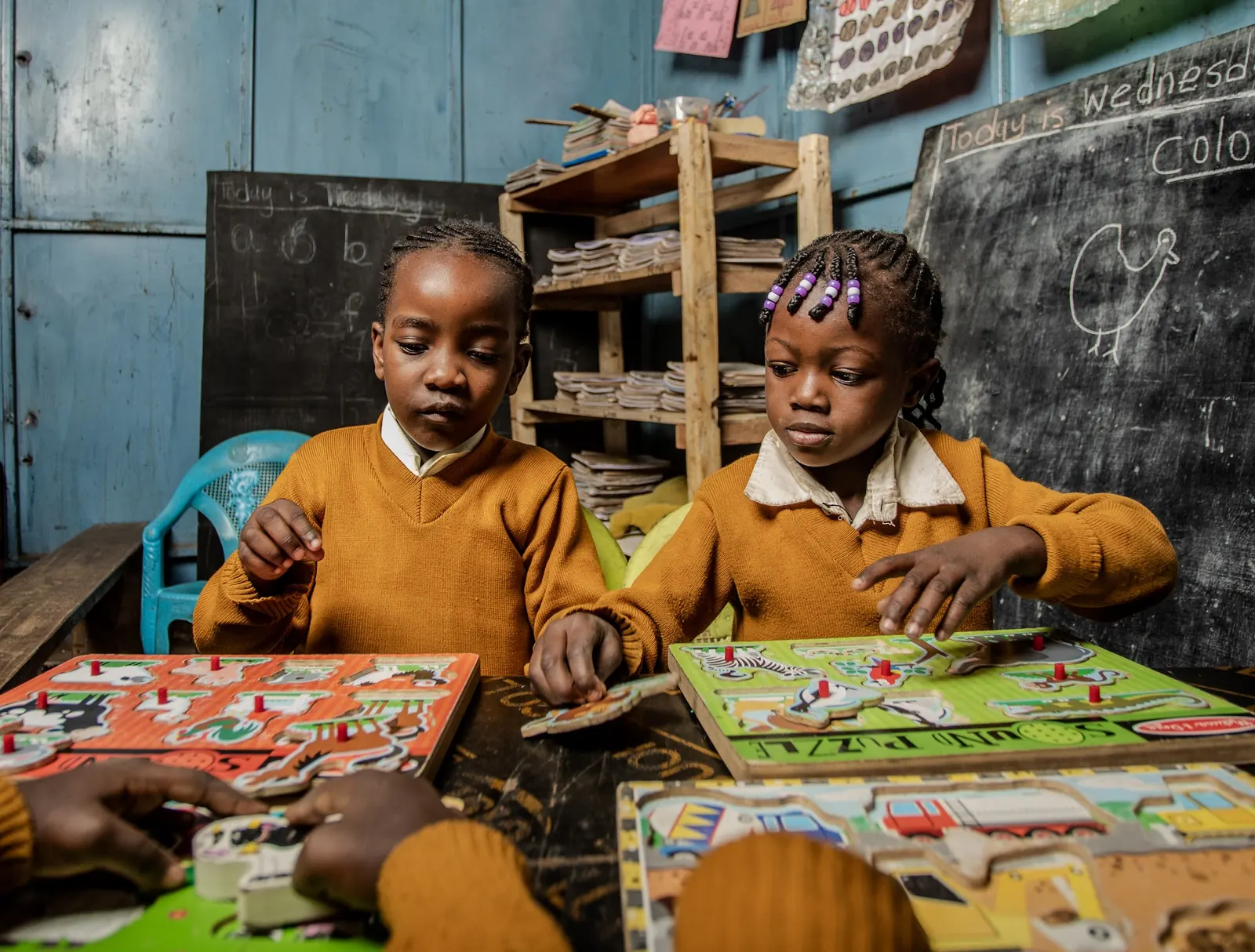 Two girls fitting pieces into wooden puzzles